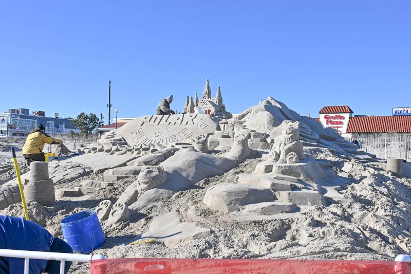 Darrell O’Connor of the Sandbears puts the finishing touches on the top of the sand art display he created with Andy West, Marc Schaffer, Heather Williams, Lynn Boyer Williams, Pete Faverio and Adam Basalyga.