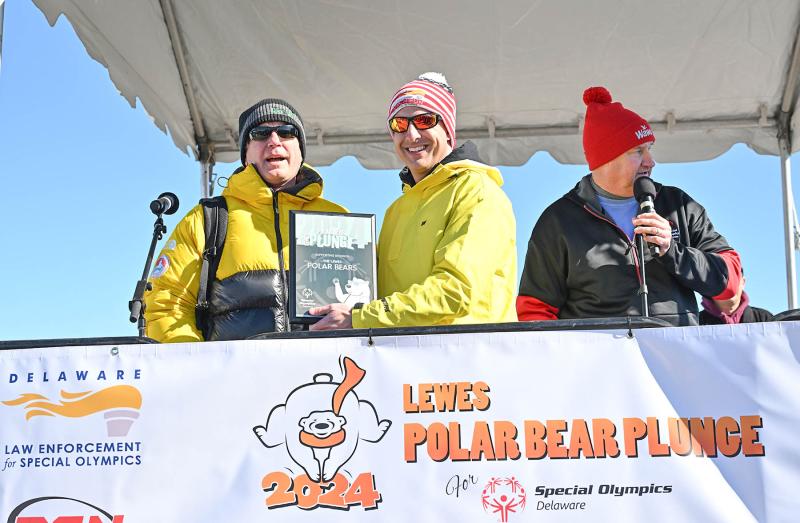 Greg Mack, one of the original Polar Bears, receives a plaque of recognition from Special Olympics Delaware President David Halley.