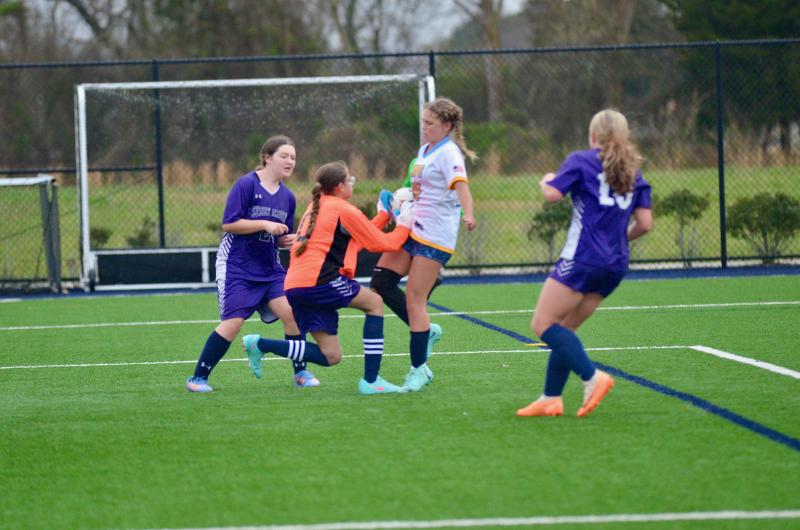 Sussex Academy sixth-grade goalie Savannah Hope comes through with a clutch save and holds onto the rebound despite slippery conditions.