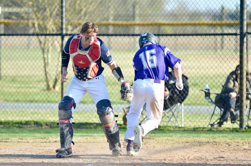 Delmarva Christian’s Garret Rogers crosses the plate just before the tag. The senior had four RBIs against the Sabres.