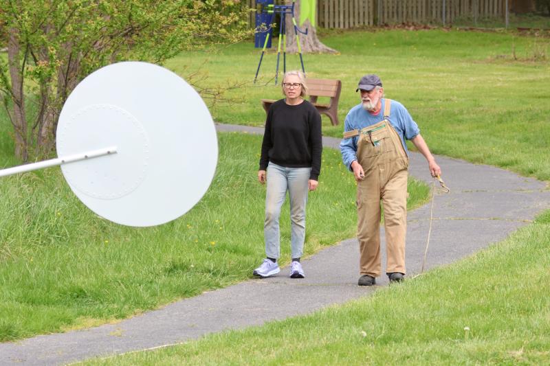 Heidi Lowe, Lewes Public Art Committee chair, walks with artist Paul Daniel. Part of the piece called “M.T. Skirt” hangs over the path. “Bad Apple” is in the background.