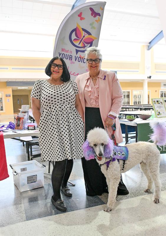 Survivor Jacqueline Valentine, left, and What is Your Voice President and Founder Jacqueline Sterbach stand with service dog Aristotle.