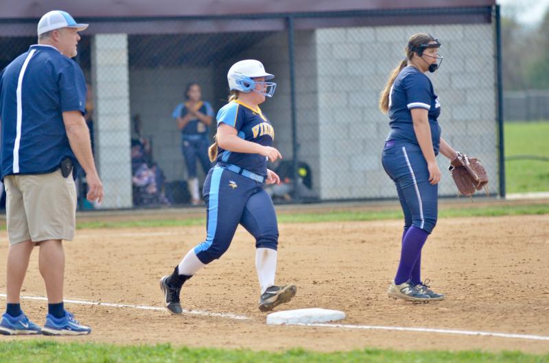 Cape’s first base coach Chuck Hudson eyes up the situation as Alivia Heers rounds first on her single to center.