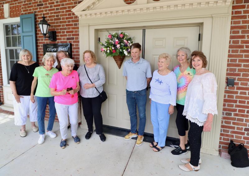 Lewes in Bloom volunteers gathered to hang a basket of fresh flowers on the city hall door April 30 to promote the organization’s fourth annual May Day decorating contest. Shown are (l-r) Sue Crawford, Betsy Hansot, Ellen McCathran, Judy Eger, Patti Walters, Mayor Andrew Williams, Bonnie Mahr, Dianne Stevens and Maureen Ciano. BILL SHULL PHOTO