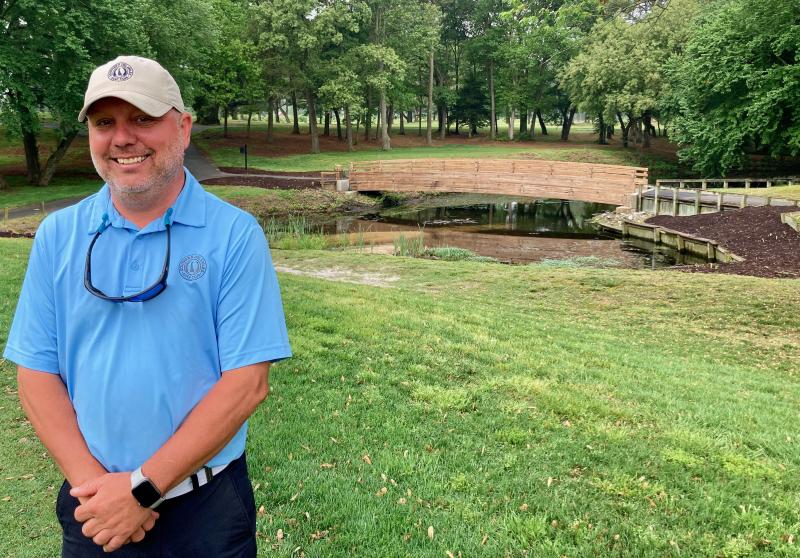 Southern Delaware Golf Club Director of Agronomy Bill Kupfer stands at the rebuilt first green shortly after the club’s May 1 soft opening for public play. The renovation removed a stand of trees behind the hole, revealing the cleaned and restained bridge for the 8th hole teeing area beyond. The work also cleared underbrush in the forest between the 8th tee and the 7th fairway.
