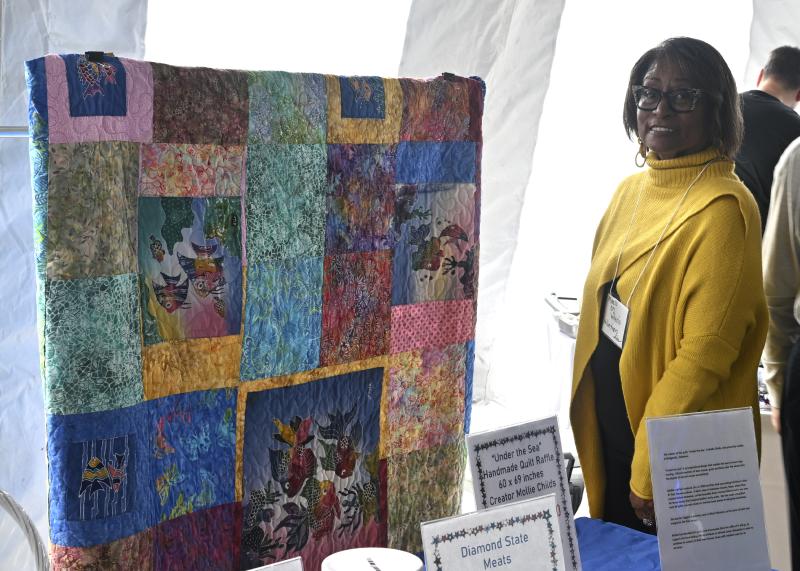 Ida Rowe showcases a quilt, “Under the Sea,” made by Mollie Childs of Bridgeville. It was one of the many items up for auction.
