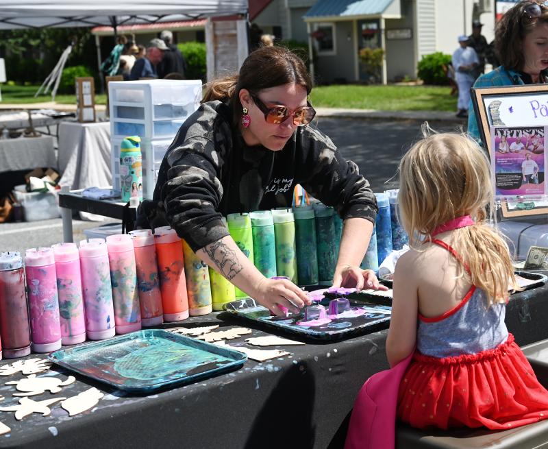 Ashley Woolsey of the Developing Artist Collaboration works with Skylar Krantz, 4, of Milton to create a magnet for Mother’s Day.