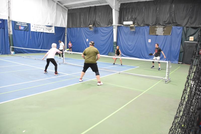Heidi Egbert plays a ball at the kitchen with her teammate Dan Daly, while Rita Magness and Jeffrey Newman are ready to defend across the net.