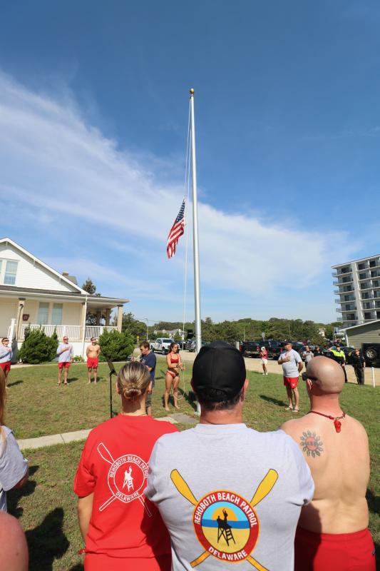 Lifeguard Maddie Kuennen raises the flag in front of the Pennsylvania Railroad house to kick off the 2024 bell-ringing ceremony.