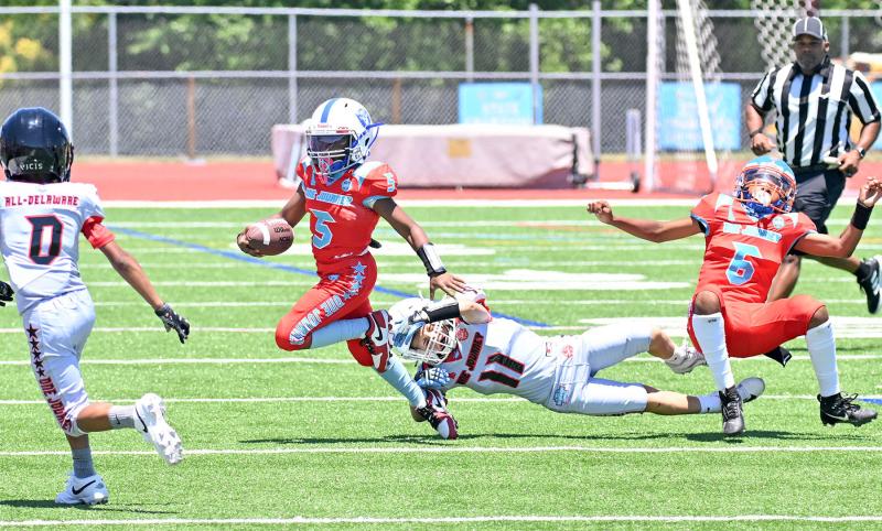 Team Red quarterback Carter Neal gets pulled down by Team Silver’s Ben Pease despite the blindside penalty.