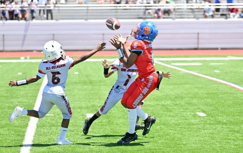 Team Red’s Zyen Oliver catches a pass and runs for a touchdown in Team Silver’s 19-56 win in the fourth- and fifth-grade showcase game.