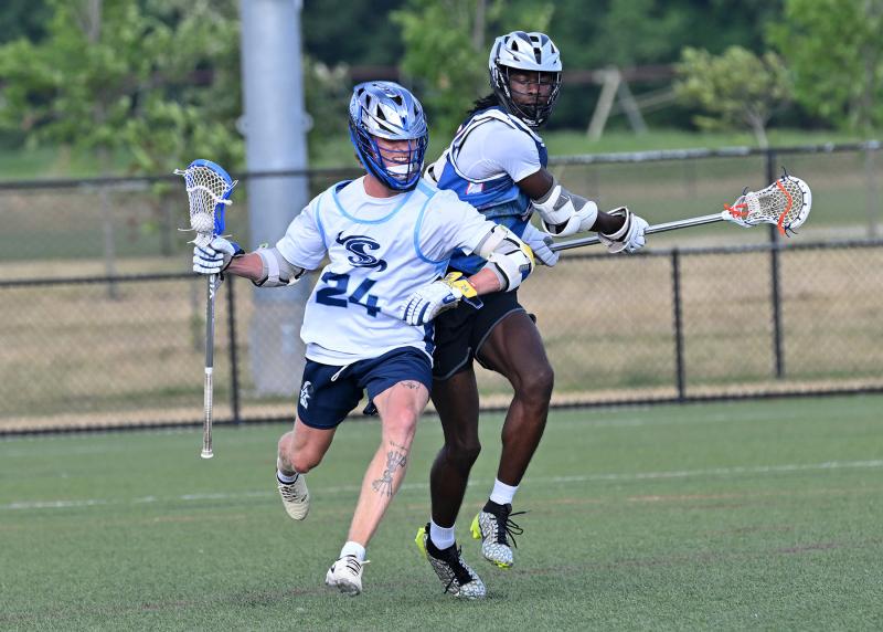 Shorebreak Lacrosse middie Hunter Jones (Rollins College) dodges past Flaming Windows defender Zymere Hopkins (Delaware Tech).