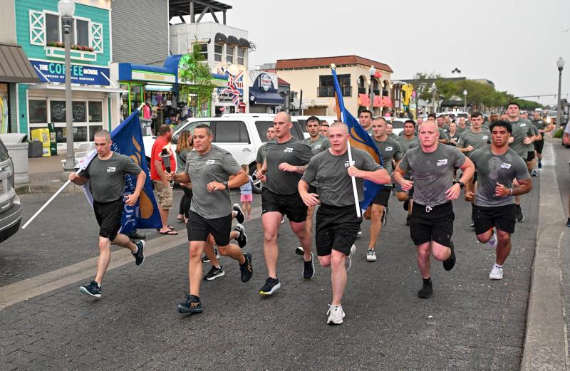 Members of the Delaware State Police and the Municipal Recruit Class arrive with the torch at the Rehoboth Beach Bandstand.