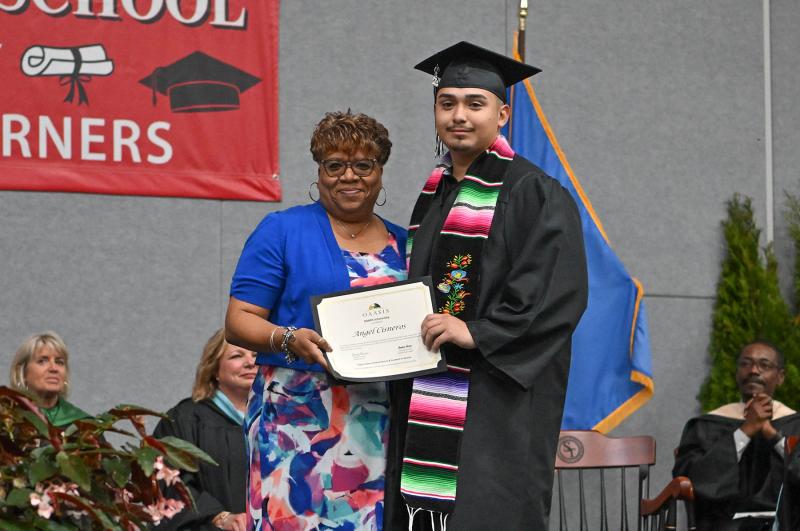 Organization of Adult Alumni and Students in Service team leader Chanteea Harmon presents the OAASIS scholarship to Angel Cisneros.