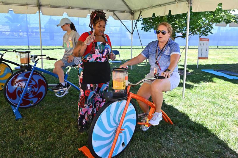 Special Olympics Delaware Director of Sport Training Cheryl Talmo spins her own frozen smoothie as Kinah Davis of Good Wheely Smoothies looks on.