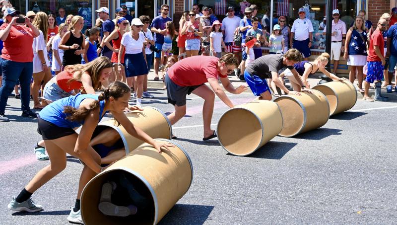 Teams compete in the barrel roll down Second Street as one of the games to celebrate Independence Day in Lewes. RON MACARTHUR PHOTO