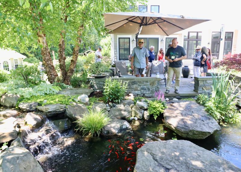 Morty Bacher, right, just fed the fish in his garden pond. He said they have had otters come up from the marsh behind their yard to snack on the fish.