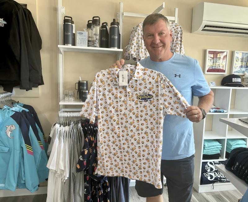 Steve “Monty” Montgomery holds a top-selling orange crush polo, now available at the new Starboard Merch Collection, directly across Coastal Highway from The Starboard in Dewey Beach. ELLEN DRISCOLL PHOTOS