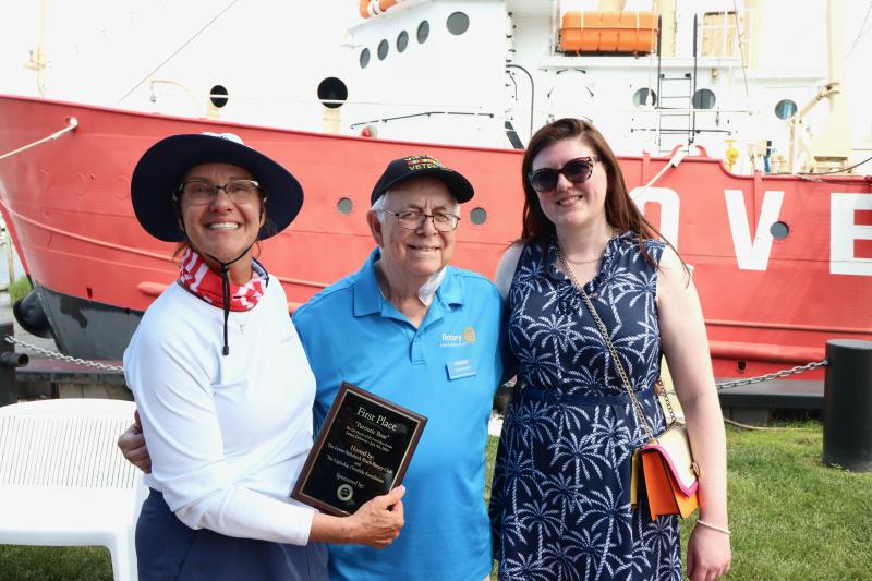Lee Ann Augustine, left, accepts the first-place award for her Sea Sisters crew from Chuck Ward, center, Lewes-Rehoboth Rotary Club past president, and Katie Millard, Lewes-Rehoboth Rotary Club president.