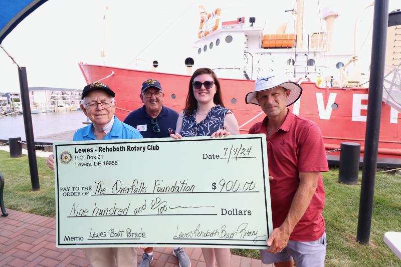The Lewes-Rehoboth Rotary Club presents a check for $900 to the Overfalls Foundation after the boat parade. Shown are (l-r) Chuck Ward, Lewes-Rehoboth Rotary Club past president; Dave Beck, Overfalls Foundation board of directors vice president; Katie Millard, Lewes-Rehoboth Rotary Club president; and Andrew Williams, Lewes mayor.