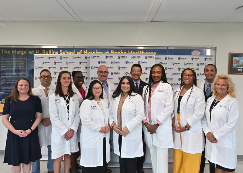 Shown in back are (l-r) Dr. Paul Sierzenski, MD, chief physician executive; Dr. Joyce Robert, MD, founding program director, Family Medicine Residency; Dr. Jeffery Hawtof, MD, director of medical education; Dr. David Tam, MD, president and CEO of Beebe Healthcare; and Dr. Ryan Arias, DO, Family Medicine Residency. In front are Tanya Ray, administrative director; Dr. Gianna Grogan, DO; Dr. Dorothy Vosik, DO; Dr. Elsa Tabrez, MD; Dr. Philande Ntock, MD; Dr. Cynthia Lamour, DO; and Dr. Wendi Schirvar, Ph.D., LP.