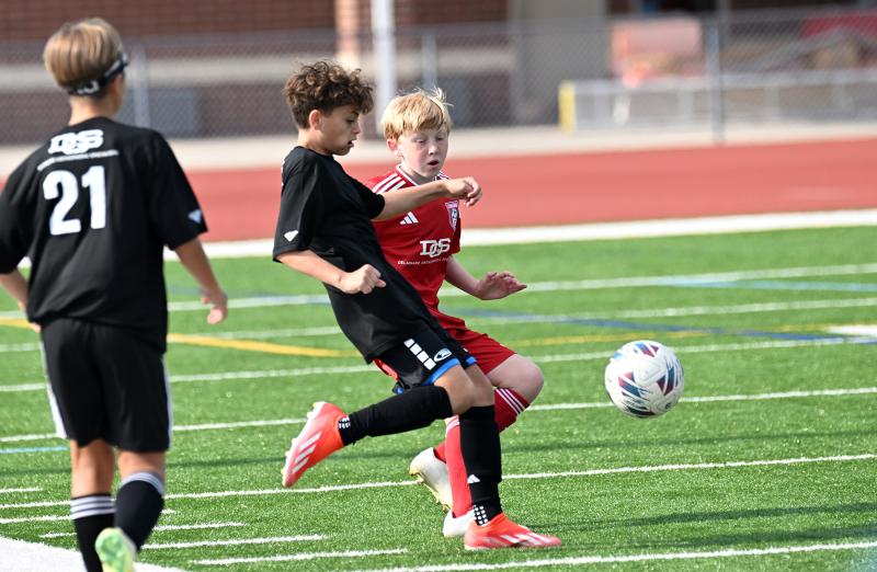 DEFC South’s Blake Jarecki kicks a centering pass away from the defense of Concord’s Landon Williams.