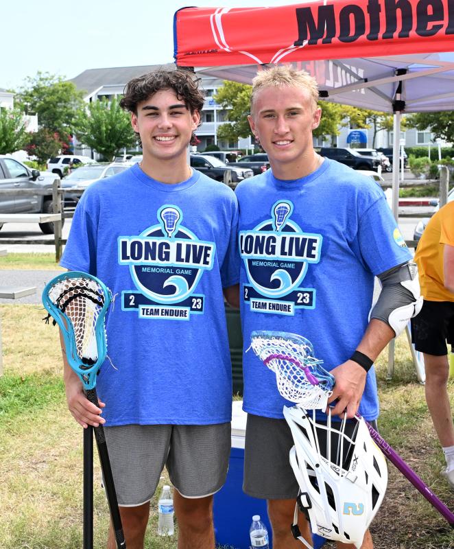 Eddie Ghabour, left, and Eddie Houck hold the Powell Brothers Lacrosse memorial sticks presented to them.