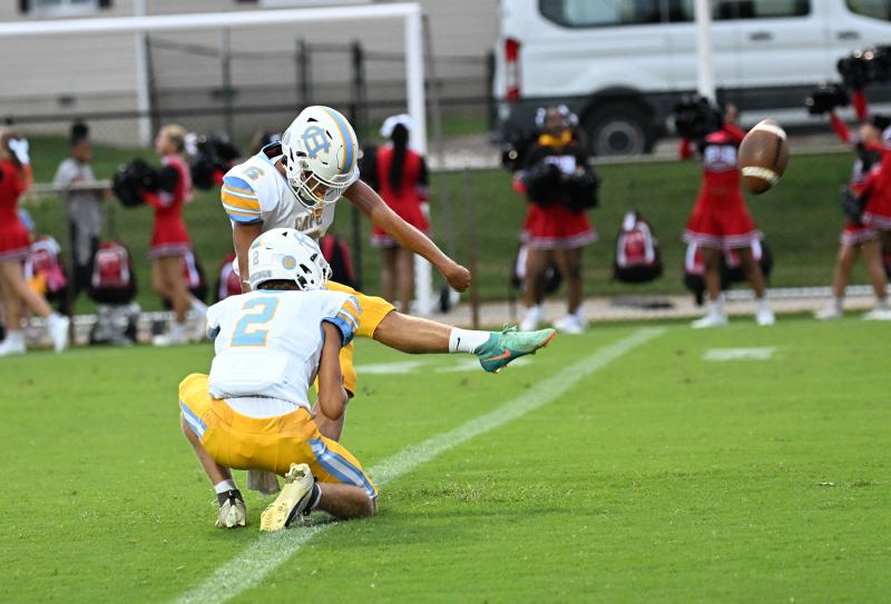 Senior placekicker Trent Kauffman boots the first extra point of his career from the hold of quarterback Mikey Thompson.