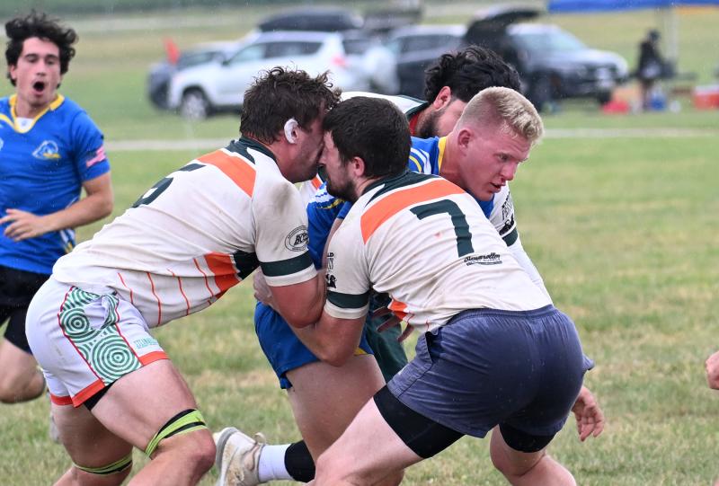 University of Delaware member John O’Donnell carries the ball as Wilmington’s Ethan Owens, left, and Bobby Bove butt heads.