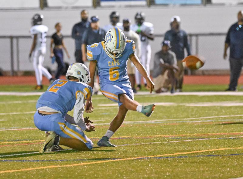 Trent Kauffman boots an extra point out of the hold of Michael Thompson. He kicked four conversions in the Cape win.
