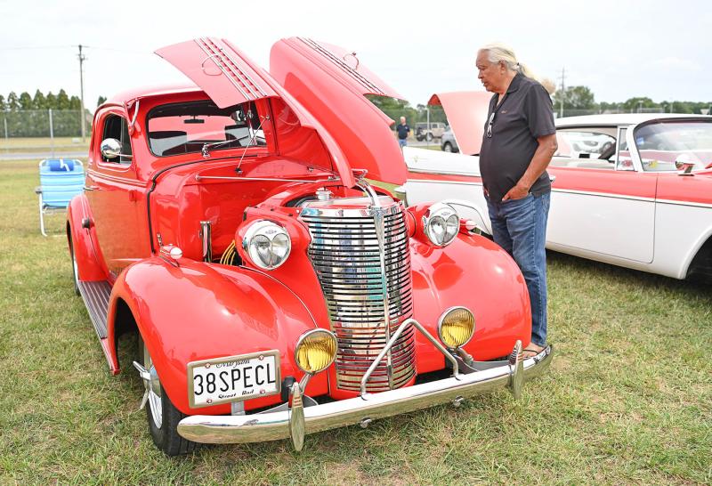 General Grant, an artist from North Carolina, admires a 1938 coupe owned by Mark Swecker at the Powwow car show.