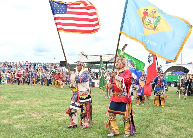 Herman Jackson, left, and Larry Jackson carry the American and Delaware flags during the grand entry of the 2024 Nanticoke Powwow.