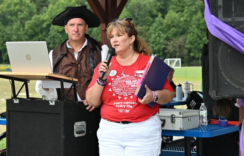 Relay for Life Chair Kathy Blanchette speaks to attendees about the importance of supporting survivors as volunteer DJ John Tomeski looks on.