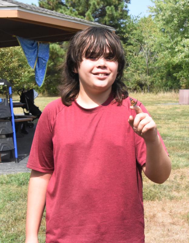 A butterfly rests on Benji Copeland’s finger before flying off.