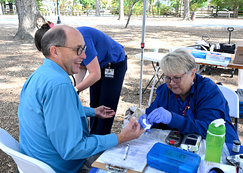 Randy Schaap gets his cholesterol and blood pressure checked by (l-r) Noelle Mills, RN, and Veronica Smith, RN.