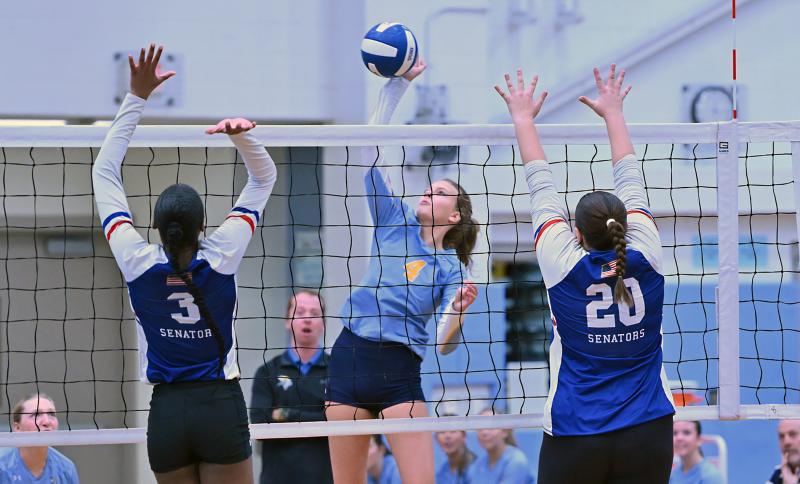 Cape sophomore Harper Mamele pounds a kill through an attempted block by Kenaysha Williams and Emma Kozel.