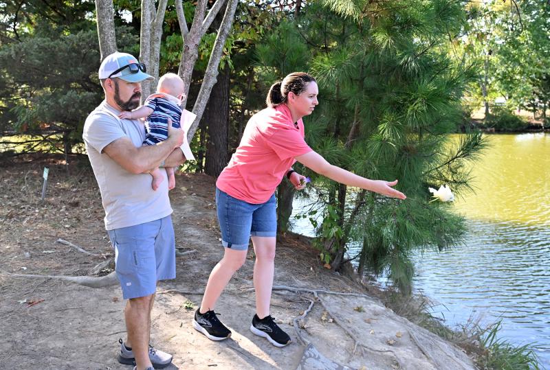 Kiernan Quay and her husband Justin Bruno toss a flower to remember their lost child. Bruno holds their rainbow baby, a term used for a child born after a loss.