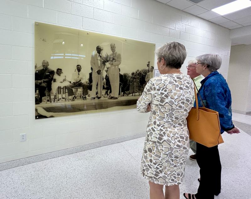 In this history wall photo, Frederick D. Thomas stands at the microphone with Lewes Mayor Otis Smith at the Jolly Jills Social Club Memorial Day parade about 1959. The club, in conjunction with Lewes Junior High and William C. Jason Comprehensive High School in Georgetown, sponsored the parade that traveled down Savannah Road, Second Street and Park Avenue before ending at the field now known as Shipcarpenter Square.