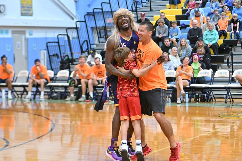 Robert Sisco and his son Peyton, 9, participate in a funny skit with Harlem Wizards player Loonatik.