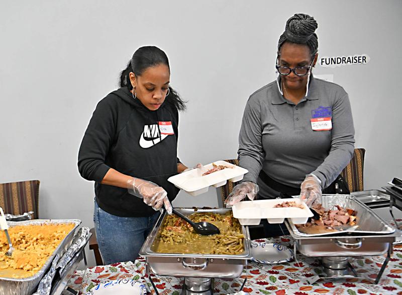 Volunteers Nina Isaac, left, and Iylona Hardy prepare the platters to be given out during the event.
