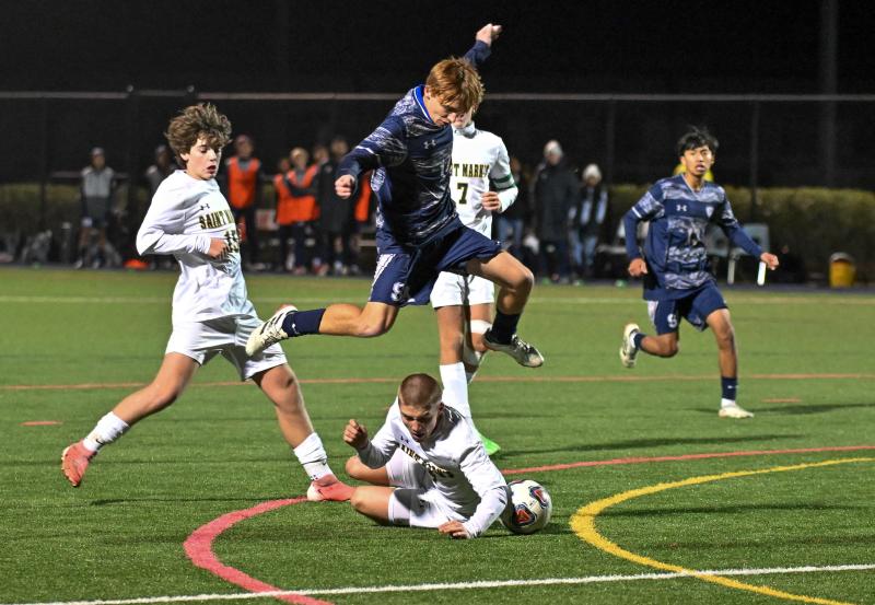 Seahawks senior Aleksander Danilenko avoids the slide tackle by Spartans senior Brandon Farina who was called with a handball on the play. The play set up the winning direct kick by Andres Romero-Nieto.