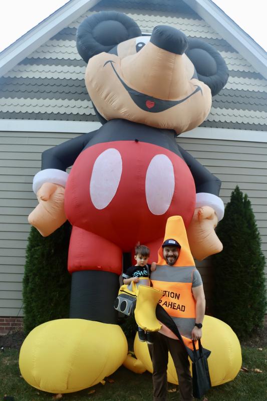 Shane Swanger holds his son Wesley, who dressed as a bulldozer, in front of a giant Mickey Mouse at Manila Avenue and Kings Highway.