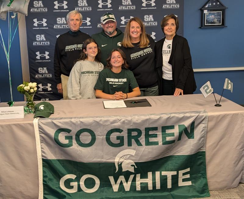 Rilyn Lehman signs her letter of intent surrounded by family. By her side is her sister/teammate Mady Lehman. Behind them are (l-r) grandfather Joseph Franchella, dad Chris, mom Nicole and grandmother Barbara Franchella.