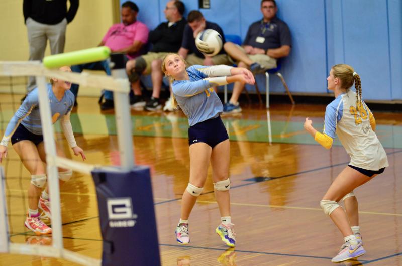 Vikings senior Mallory Terhune receives a serve while Ava Calciano, left, and Amara Fruchtman wait to react.