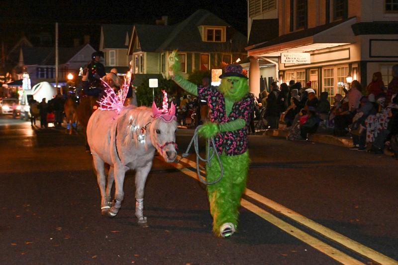 The Pairadice Equestrian Grinch, aka Camille Kierstead, walks their horse Knotty up the parade route.