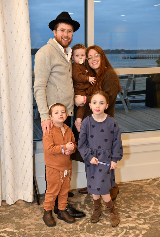 Posing for a family portrait at the event are Rabbi Sholom Vogel, Chabad of Southern Delaware director; and his wife and co-director Chanale holding 18-month-old Zeesa. In front are Efraim, 31/2, and Musya, 6.