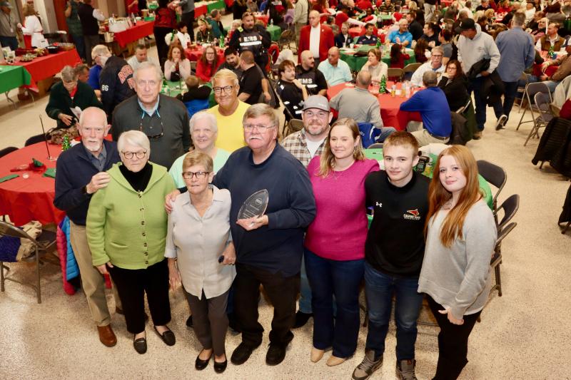 Chuck Snyder holds his Citizen of the Year award while posing with his family at the Community Unity dinner. Snyder said he is most proud of his kids and his passion to give back to the community.