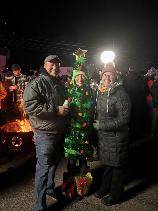 Dewey Business Partnership tree lighting attendees (l-r) Chris Avsec, Ava Cannon and Katie Avsec keep warm by the fire.