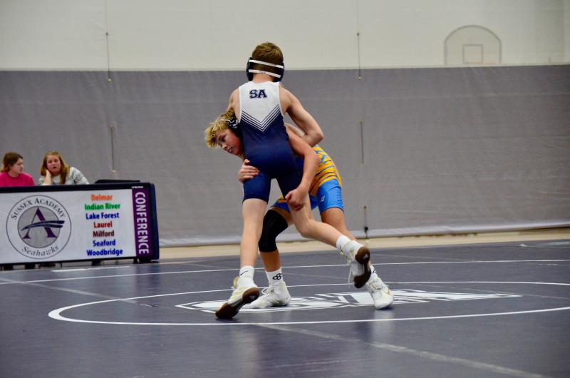 Vikings seventh-grader Brodie Godbout tries for a double-leg takedown on Seahawks seventh-grader Liam Clark in the 100-pound match.