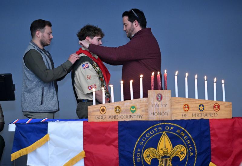 Ian Campbell’s Eagle Scout brothers Steven Matalavage, left, and David Campbell, participate in the neckerchief transition during the Court of Honor ceremony.